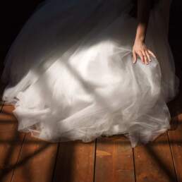 La mano della sposa mentre sistema il vestito